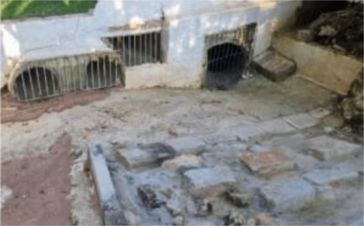 Registro da condição anterior à intervenção, com área externa e piso degradado/irregular, indicando necessidade de adequação do escoamento superficial e captação de águas pluviais.